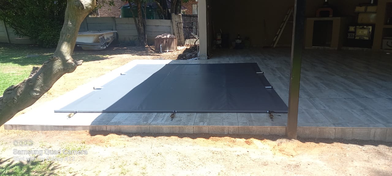 Sleek black PVC cover on covered patio pool with ratchet system